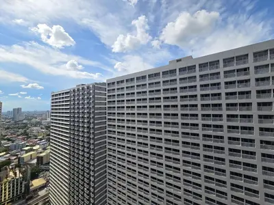 a tall white building with a sky at 1BR Condotel with Balcony at FAME Residences #FM50-1 in Manila