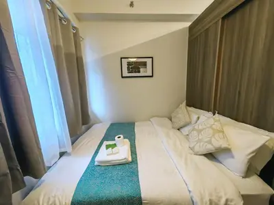 a hotel room with a bed with a tray on it at 1BR Condotel with Balcony at FAME Residences #FM51-1 in Manila