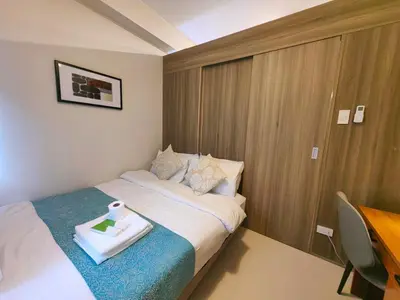 a hotel room with a bed with a tray on it at 1BR Condotel with Balcony at FAME Residences #FM51-1 in Manila