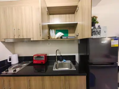 a kitchen with a sink and a black refrigerator at 1BR Condotel with Balcony at FAME Residences #FM51-1 in Manila