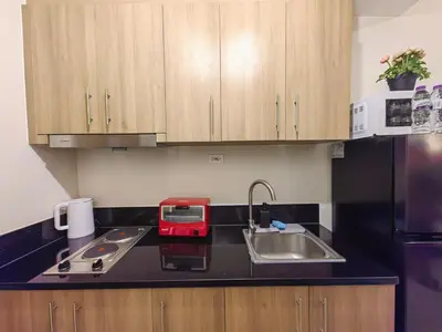 a kitchen with a sink and a red appliance on a counter at 1BR Condotel with Balcony at FAME Residences #FM51-1 in Manila