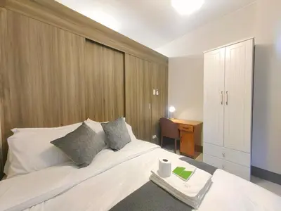 a bedroom with a white bed with a desk and a chair at 1BR Condotel with Balcony at FAME Residences #FM47-1 in Manila