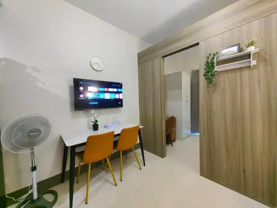 a room with a table and chairs and a tv at 1BR Condotel with Balcony at FAME Residences #FM47-1 in Manila
