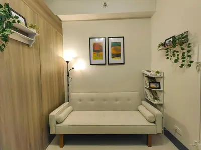 a living room with a white couch in a room at 1BR Condotel with Balcony at FAME Residences #FM47-1 in Manila