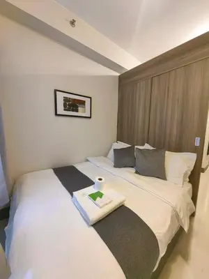 a hotel room with two beds with a tray on it at 1BR Condotel with Balcony at FAME Residences #FM47-1 in Manila