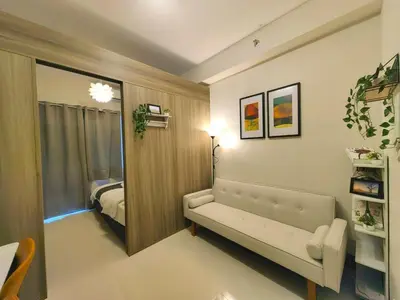 a living room with a couch and a bedroom at 1BR Condotel with Balcony at FAME Residences #FM47-1 in Manila
