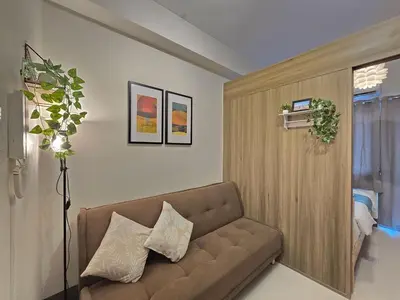 a living room with a brown couch in a room at 1BR Condotel with Balcony at FAME Residences #FM48-1 in Manila