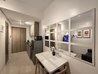 a small kitchen with a table and a refrigerator at 1BR Condotel with Balcony at FAME Residences #FM49-1 in Manila