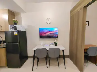 a kitchen with a table and two chairs and a refrigerator at 1BR Condotel with Balcony at FAME Residences #FM52-1 in Manila