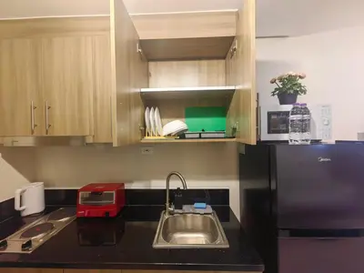 a kitchen with a sink and a refrigerator at 1BR Condotel with Balcony at FAME Residences #FM52-1 in Manila
