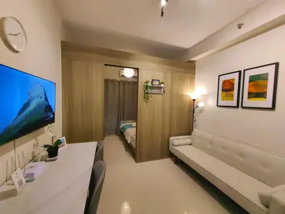 a hotel room with a couch and a bedroom at 1BR Condotel with Balcony at FAME Residences #FM52-1 in Manila