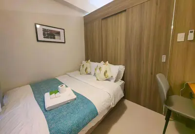 a hotel room with a bed with a tray on it at 1BR Condotel with Balcony at FAME Residences #FM52-1 in Manila