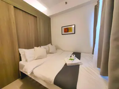 a hotel room with a bed with a table on it at 1BR Condotel with Balcony at FAME Residences #FM53-1 in Manila
