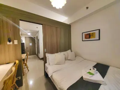 a hotel room with a bed and a table at 1BR Condotel with Balcony at FAME Residences #FM53-1 in Manila