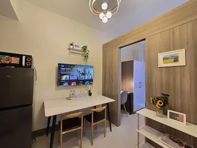 a small room with a table and a refrigerator at 1BR Condotel with Balcony at FAME Residences #FM54-1 in Manila