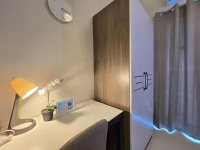 a room with a desk with a lamp and a clock at 1BR Condotel with Balcony at FAME Residences #FM54-1 in Manila