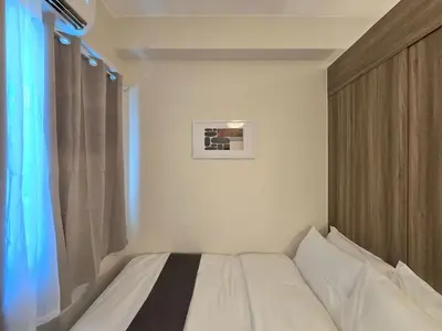 a bedroom with a white bed with a window at 1BR Condotel with Balcony at FAME Residences #FM56-1 in Manila