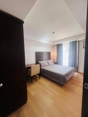 a bedroom with a bed and a desk in it at Poblacion Makati Condo in Manila