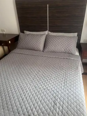 a large bed in a bedroom with a wooden headboard at Poblacion Makati Condo in Manila