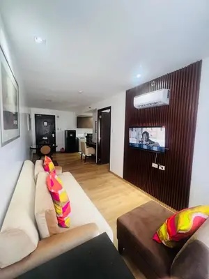 a living room with a couch and a flat screen tv at Poblacion Makati Condo in Manila