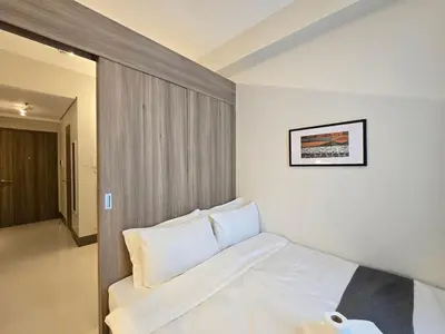 a bedroom with a bed with white pillows at 1BR Condotel with Balcony at FAME Residences #FM58-1 in Manila