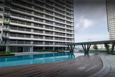 a large building with a swimming pool in front of it at 1BR Condotel with Balcony at FAME Residences #FM58-1 in Manila