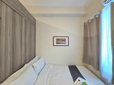 a white bed in a room with a window at 1BR Condotel with Balcony at FAME Residences #FM58-1 in Manila