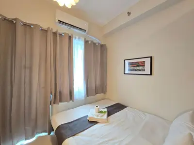 a bedroom with a bed and a window with a tray on it at 1BR Condotel with Balcony at FAME Residences #FM59-1 in Manila