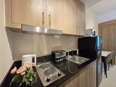 a kitchen with a counter with a sink and a refrigerator at 1BR Condotel with Balcony at FAME Residences #FM59-1 in Manila