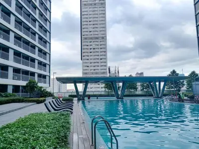 a swimming pool with a bridge in a city at 1BR Condotel with Balcony at FAME Residences #FM60-1 in Manila