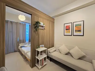 a living room with a couch and a bed at 1BR Condotel with Balcony at FAME Residences #FM60-1 in Manila