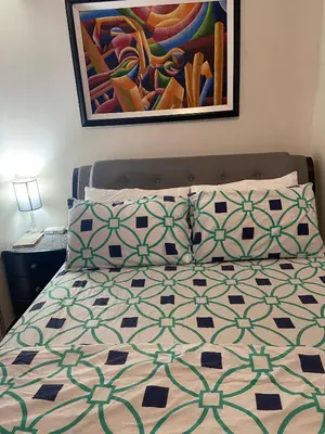 a bed with two pillows and a painting on the wall at Lumiere Residences in Manila