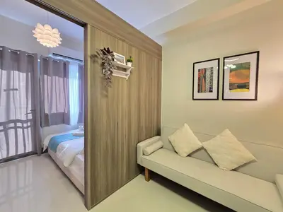 a living room with a couch and a bedroom at 1BR Condotel with Balcony at FAME Residences #FM63-1 in Manila