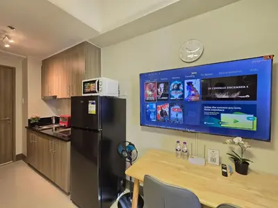 a kitchen with a black refrigerator and a table at 1BR Condotel with Balcony at FAME Residences #FM63-1 in Manila