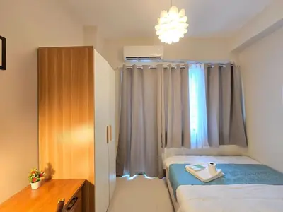 a small bedroom with a bed and a window at 1BR Condotel with Balcony at FAME Residences #FM64-1 in Manila