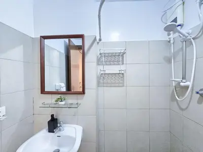 a white bathroom with a sink and a mirror at 1BR Condotel Ridgewood Towers Near Airport #RW02-1 in Manila