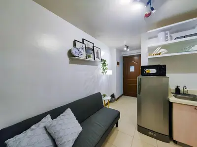 a living room with a couch and a kitchen at 1BR Condotel Ridgewood Towers Near Airport #RW03-1 in Manila