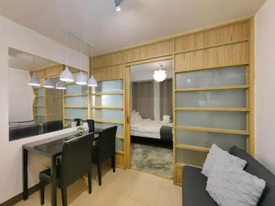 a living room with a dining table and a bedroom at 1BR Condotel Ridgewood Towers Near Airport #RW03-1 in Manila