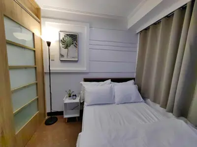 a bedroom with a white bed and a lamp at 1BR Condotel Ridgewood Towers Near Airport #RW05-1 in Manila