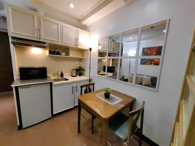 a kitchen with a table and a small kitchen with a table and chairs at 1BR Condotel Ridgewood Towers Near Airport #RW05-1 in Manila