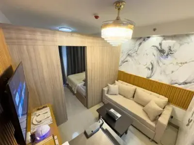 a living room with a couch and a television at MOA Staycation at Shore 2 Residences Tower 3 in Manila
