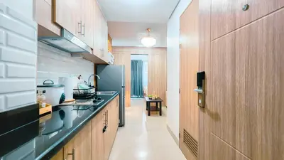 a kitchen with wooden cabinets and a blue refrigerator at MOA Staycation at Shore 2 Residences Tower 3 in Manila