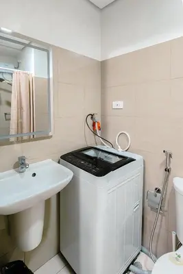 a bathroom with a sink and a washing machine at MOA Staycation at Shore 2 Residences Tower 3 in Manila
