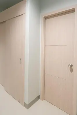 a wooden door in a room with a white wall at Relax Condotel in Manila
