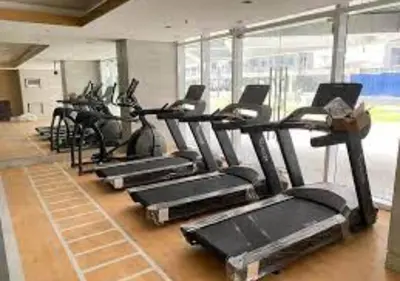 a gym with a row of tread machines in a room at Relax Condotel in Manila