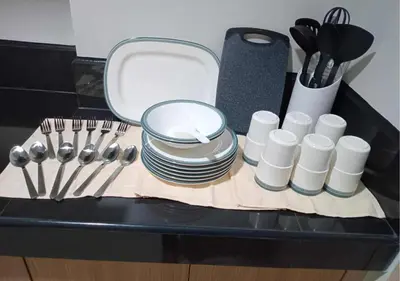 a kitchen counter with plates and utensils on a table at Relax Condotel in Manila