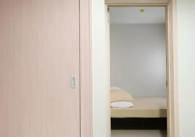 a door to a bedroom with a bed and a mirror at Relax Condotel in Manila