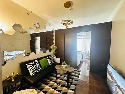 a living room with a couch and a table at MyScape at Air Residences Makati in Manila