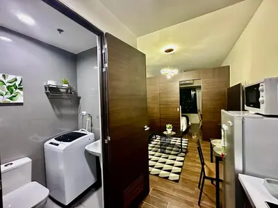a bathroom with a toilet and a sink and a television at MyScape at Air Residences Makati in Manila