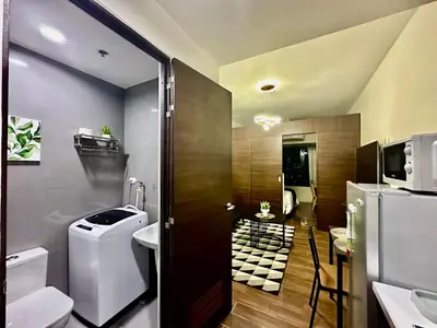 a bathroom with a toilet a sink and a microwave at MyScape at Air Residences Makati in Manila